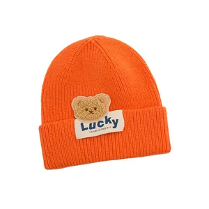 Berretto neonato in maglia a coste arancione neon con toppa orsetto ed etichetta Lucky