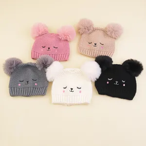 Detailed flat lay of baby knit hats in five colors with cute animal face embroidery