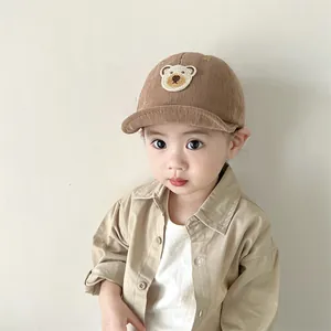Detail of baby corduroy baseball cap with cute embroidered bear on the front panel