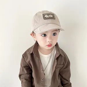 Close-up of baby beige corduroy baseball cap with K letter embroidery patch on child model
