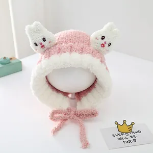 Detailed view of pink plush rabbit hat with ears and chin strap for toddlers
