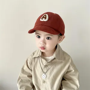 Close-up of corduroy baseball cap texture with a white embroidered letter A for kids