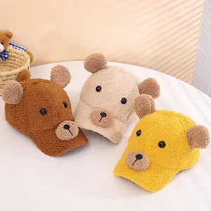 Dettaglio di tre cappellini da baseball in pile con orecchie da orso in marrone e giallo
