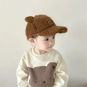 Dettaglio del cappellino sherpa caramello con orecchie da orso e felpa coordinata con orsetto