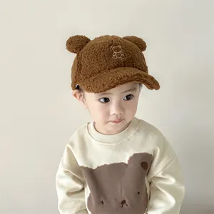Dettaglio cappellino neonato in pile marrone con orecchie d'orso e ricamo