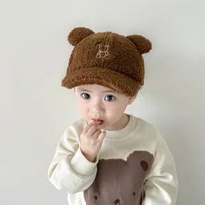Dettaglio cappello in peluche marrone per bambini con orecchie da orso e consistenza morbida