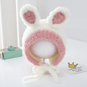Detail of plush baby winter hat with cute bunny ears and pink pompom ties