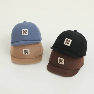 Detailed texture of corduroy baby baseball caps with K patch in four different colors