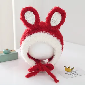 Detail of red plush baby bunny hat with white crochet trim and ear flaps