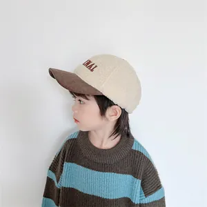 Detail of kids sherpa baseball cap with contrast brown corduroy brim and letter embroidery