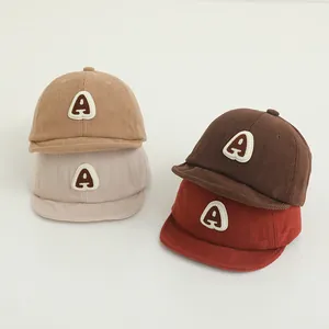 Close-up of baby corduroy baseball caps in autumn colors with embroidered A letter patch