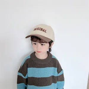 Close-up of sherpa baseball cap with letter embroidery and contrast corduroy brim