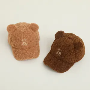 Dettaglio cappellini per bambini in lana sherpa con orecchie d'orso e ricamo fine