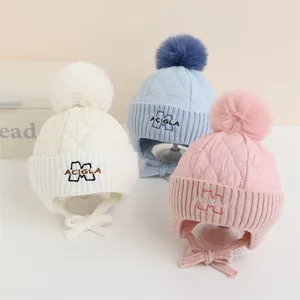 Tre cappelli invernali per bambini con pompon e paraorecchie in vari colori
