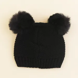 Cute black knit children's winter hat featuring dual fluffy faux fur pom-poms on top