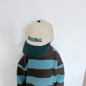 Close-up of children's winter cap with ORIGINAL embroidery and green corduroy brim