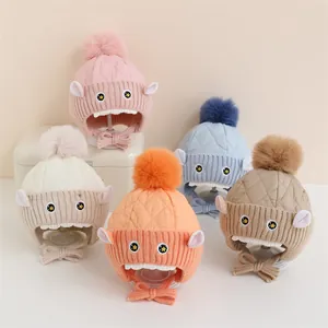 Détail de bonnets d'hiver colorés avec pompons et broderies d'animaux mignons
