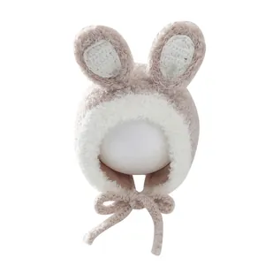 Plush bunny ear trapper hat for kids with windproof straps in warm beige and white