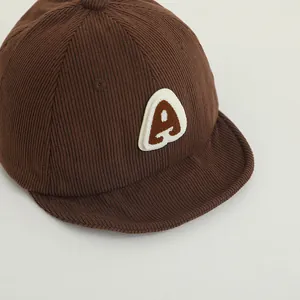 Detail of soft corduroy fabric texture and letter A embroidery on baby baseball cap