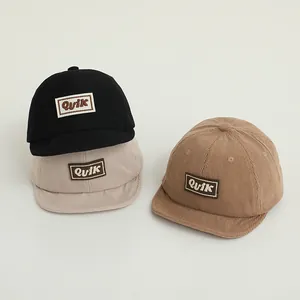 Three corduroy baseball caps in black, beige, and camel with Quik embroidered patch