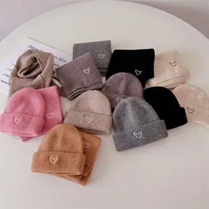 Détails de bonnets et écharpes en maille côtelée avec motif de cœur brodé