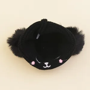 Cute black knit cat beanie for toddlers featuring faux fur pom-poms and embroidered face