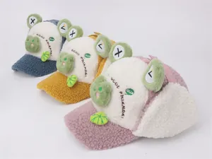 Detail view of winter cartoon frog hats in blue yellow and pink fleece with ear flaps