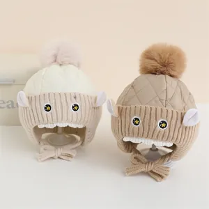 Bonnets d'hiver pour bébé avec pompons et yeux de dessin animé en beige et kaki avec cache-oreilles