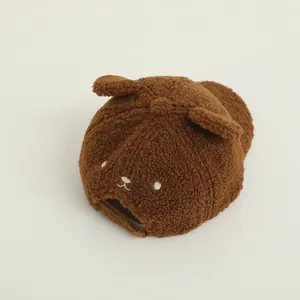 Dettaglio del cappellino per neonati in velluto marrone con orecchie d'orso e ricamo dolce