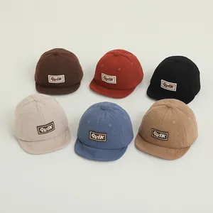 Detailed view of six colors of corduroy baby baseball caps with Quik letter patches