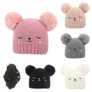 Cute baby knit beanie with double faux fur pom-poms and embroidered cartoon face design