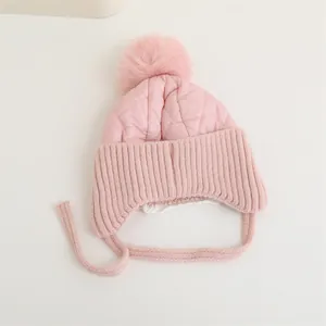 Détail du bonnet d'hiver rose pour bébé avec pompon et doublure chaude en polaire