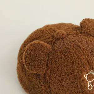 Dettaglio del tessuto sherpa marrone e del ricamo a forma di orso sul cappello bimbi