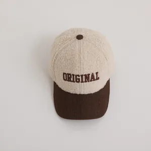 Detail of winter baseball cap showing cream sherpa fabric and brown corduroy brim texture