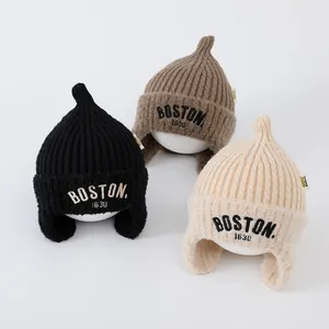 Kids knitted beanie with BOSTON 1630 embroidery and ear flaps in three winter colors