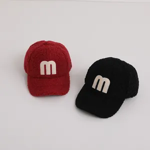 Detail showing plush polar fleece texture and embroidered letter M on baseball caps