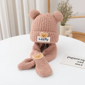 Detail of pink plush bear ear hat and scarf set showing soft faux fur texture and embroidery