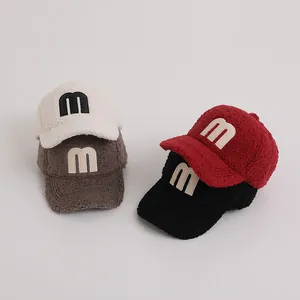 Close-up of four fleece baseball caps in cream, tan, burgundy, and black with M embroidery