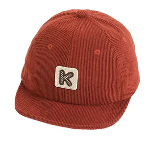 Kids corduroy baseball cap in rust red with K letter patch on front for toddlers