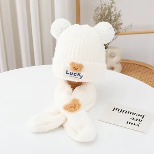 Detail of soft plush baby winter hat and scarf set with cute bear ears in cream white