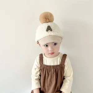 Vue détaillée du bonnet d'hiver pour bébé en polaire pelucheuse avec pompon décoratif