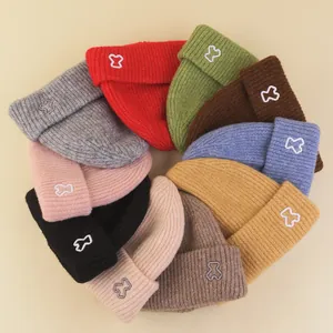 Set of colorful knitted winter hats for children with cute embroidery and ribbed design