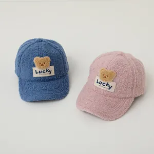 Detail of plush fleece bear baseball caps in blue and pink with Lucky tags for autumn winter