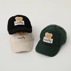 Detail of plush bear patch and Lucky label on warm sherpa baseball caps in three colors