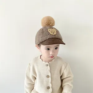 Detail of baby winter baseball hat with cute bear embroidery and faux fur pompom