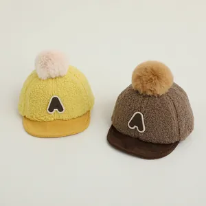 Détail de casquettes de baseball en peluche pour bébé avec pompons et broderie A
