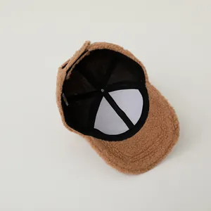 Internal detail of brown teddy fleece baseball cap showing lining and stitching