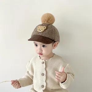 Close-up of baby winter baseball cap with plush bear embroidery and soft faux fur texture
