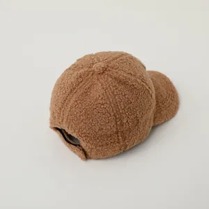 Detail of adjustable back closure on a brown fuzzy teddy fleece baseball cap for kids
