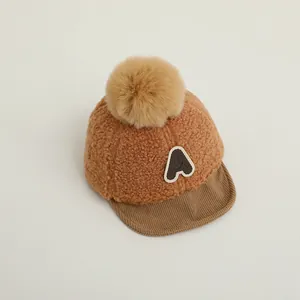 Détail du bonnet d'hiver pour bébé avec texture polaire et pompon moelleux au sommet